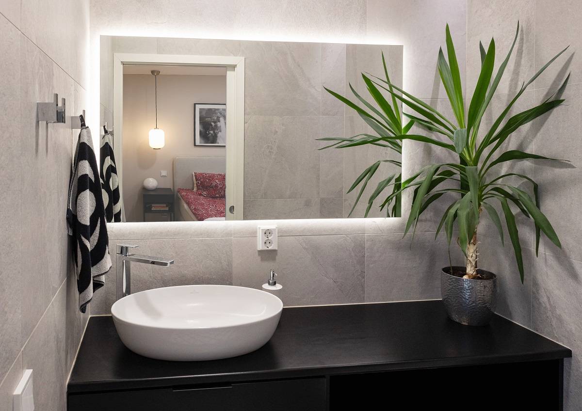 Derrière le miroir, une bande lumineuse LED éclaire indirectement.