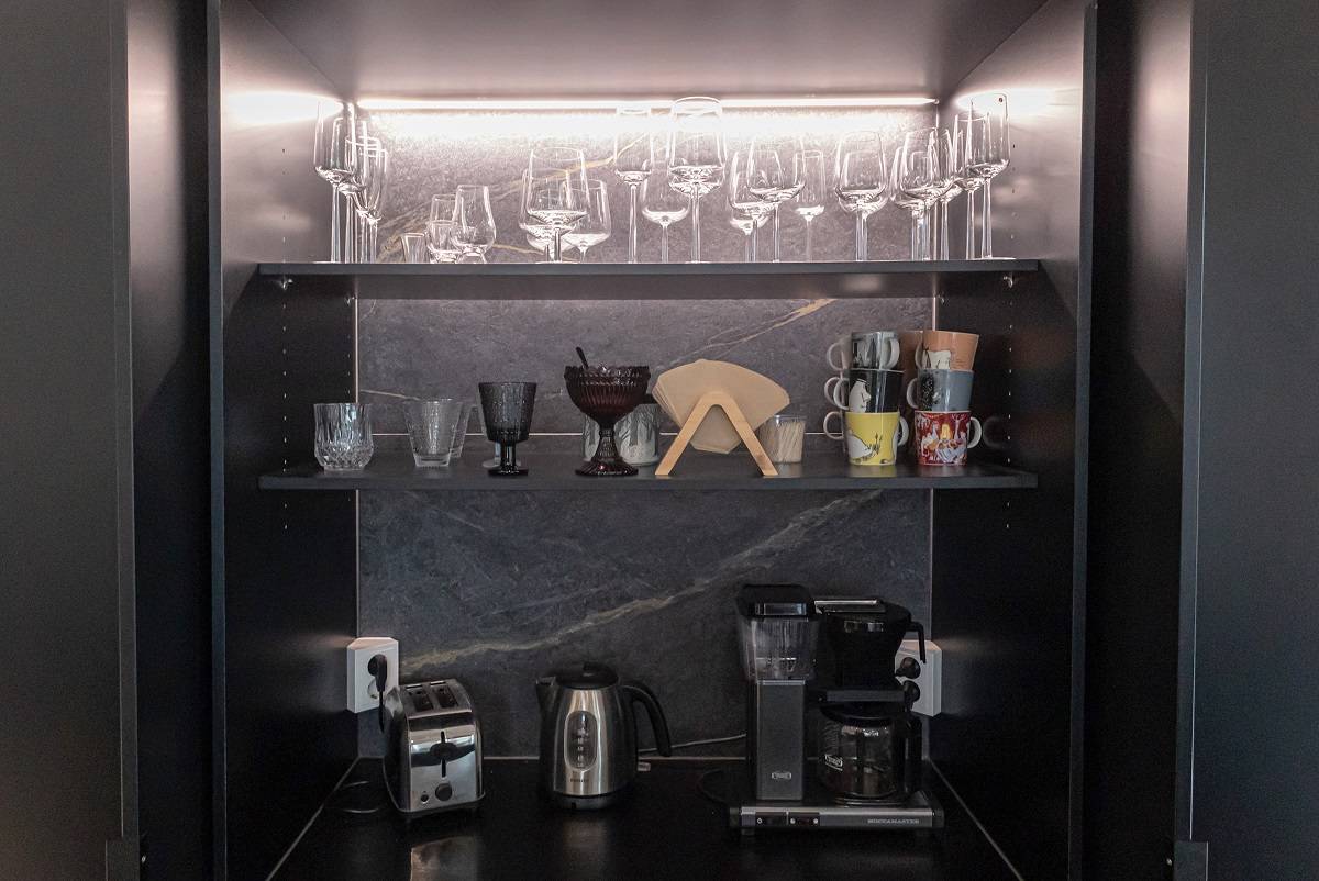 Ruban LED sur le bord arrière de l'étagère supérieure d'un meuble de petit déjeuner.