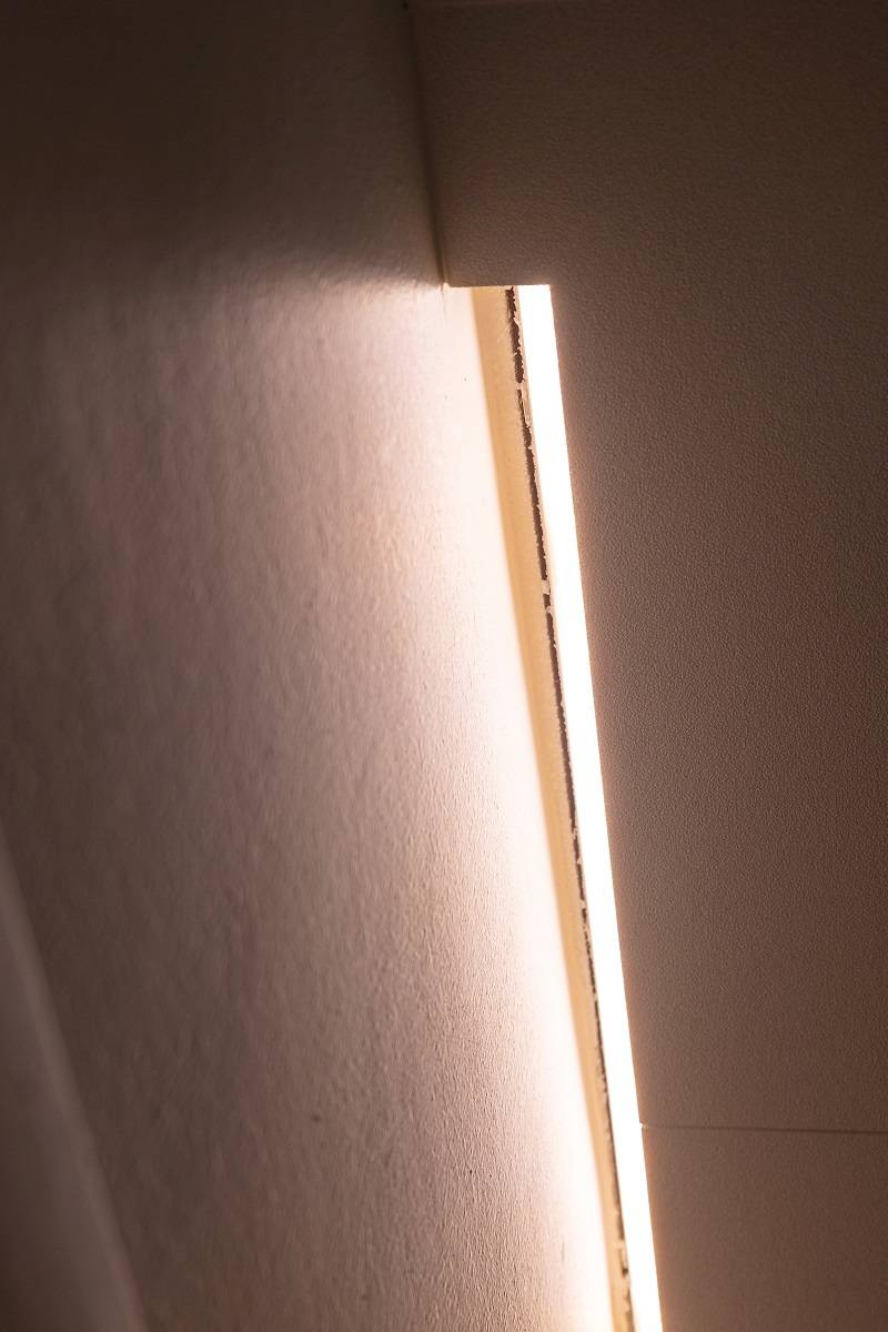 Bande LED dans le renfoncement entre le renfoncement et le mur.