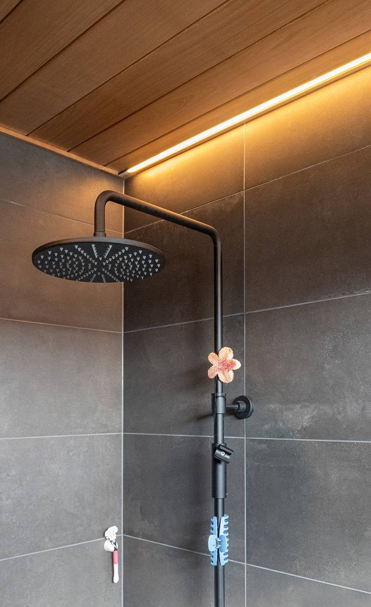 Salle de bains avec bande LED encastrée dans le plafond à côté du mur.