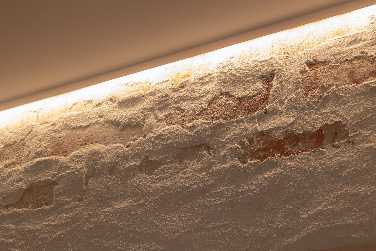 Bande LED installée sur le bord supérieur du mur d'accent pour éclairer vers le bas.