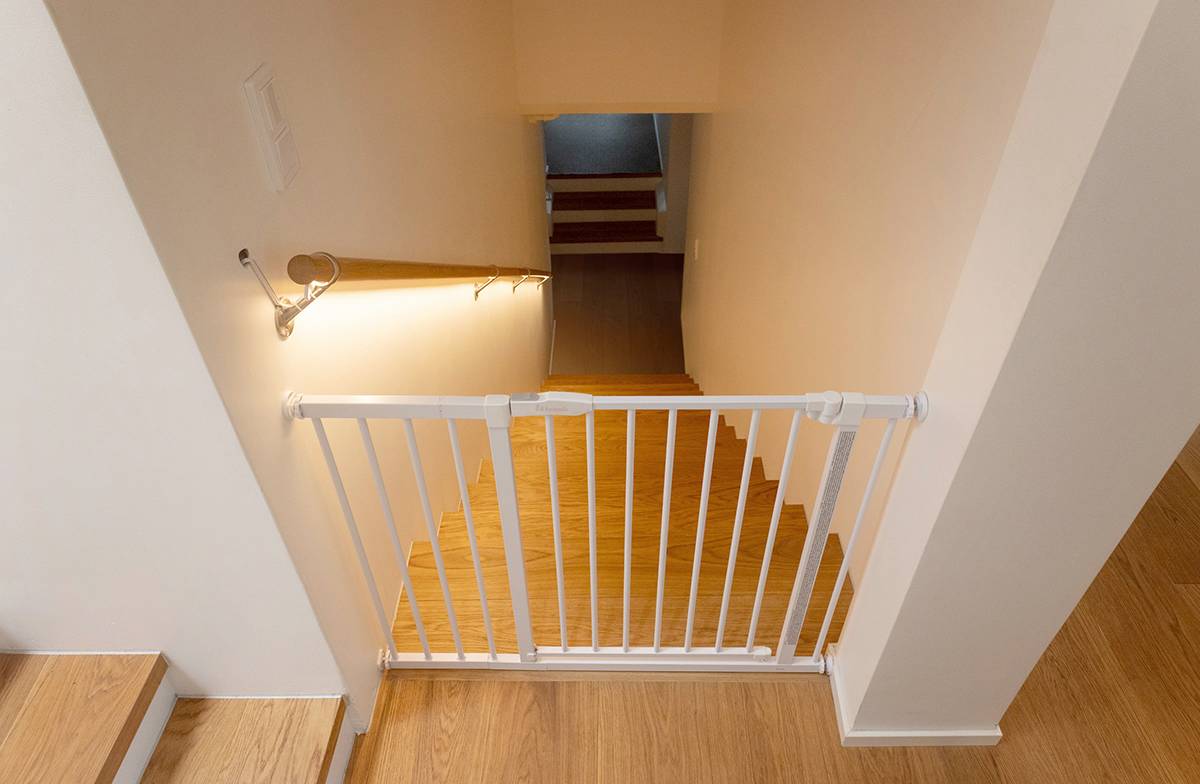 Une bande LED installée sous la rampe d'escalier éclaire les marches vers le bas.