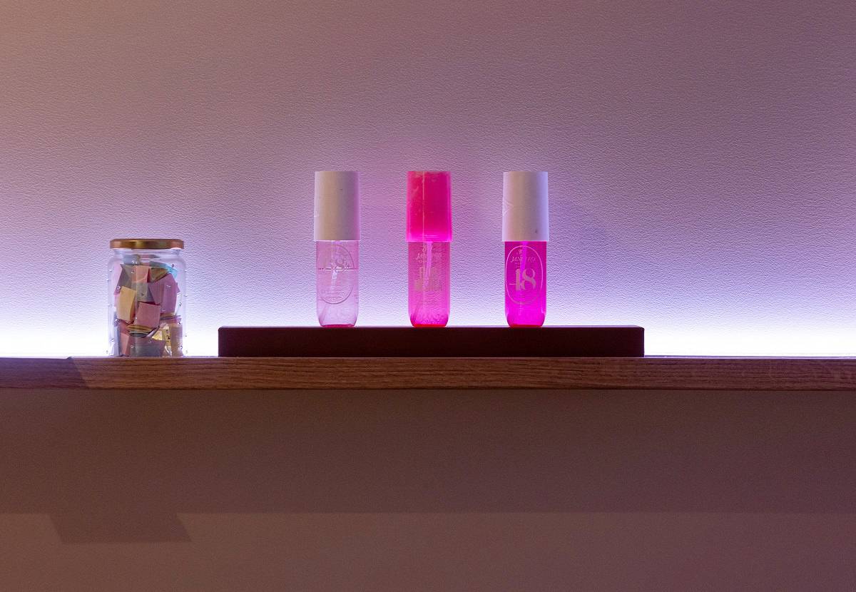 Une bande LED à couleur réglable, installée derrière l'étagère, projette une lueur violette sur le mur.