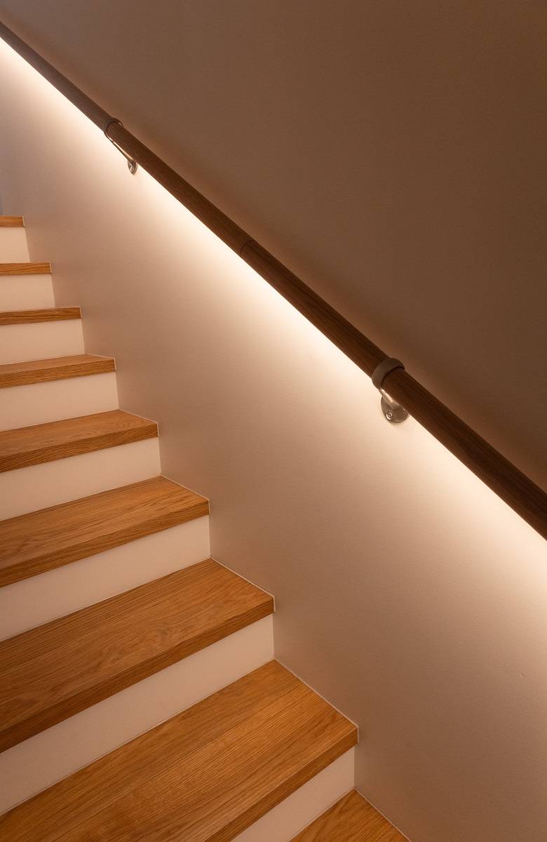 Une lumière brille sous la rampe de l'escalier.