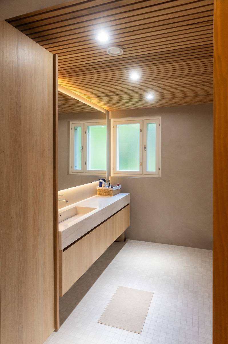 Des spots au plafond de la salle de bains et une bande LED derrière le miroir.
