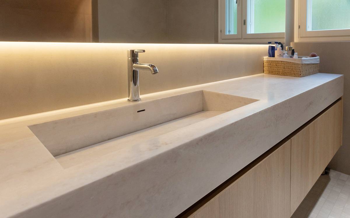 Une bande LED placée derrière le miroir éclaire le plan de lavabo.