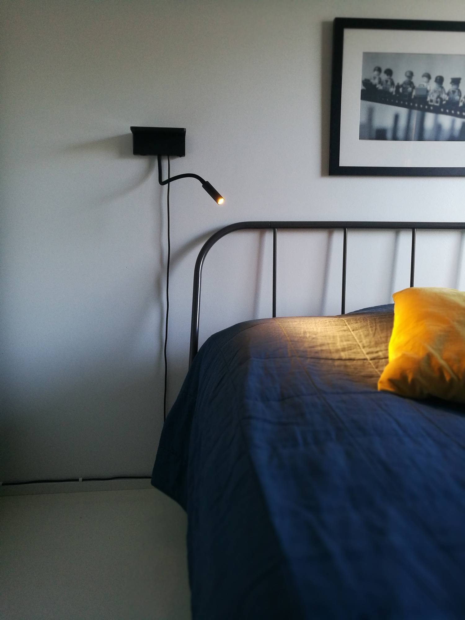 L\'applique murale BLADE se trouve à côté du lit. Elle fait office de liseuse et permet de recharger votre téléphone de manière fixe ou sans fil. Ledstore.fi