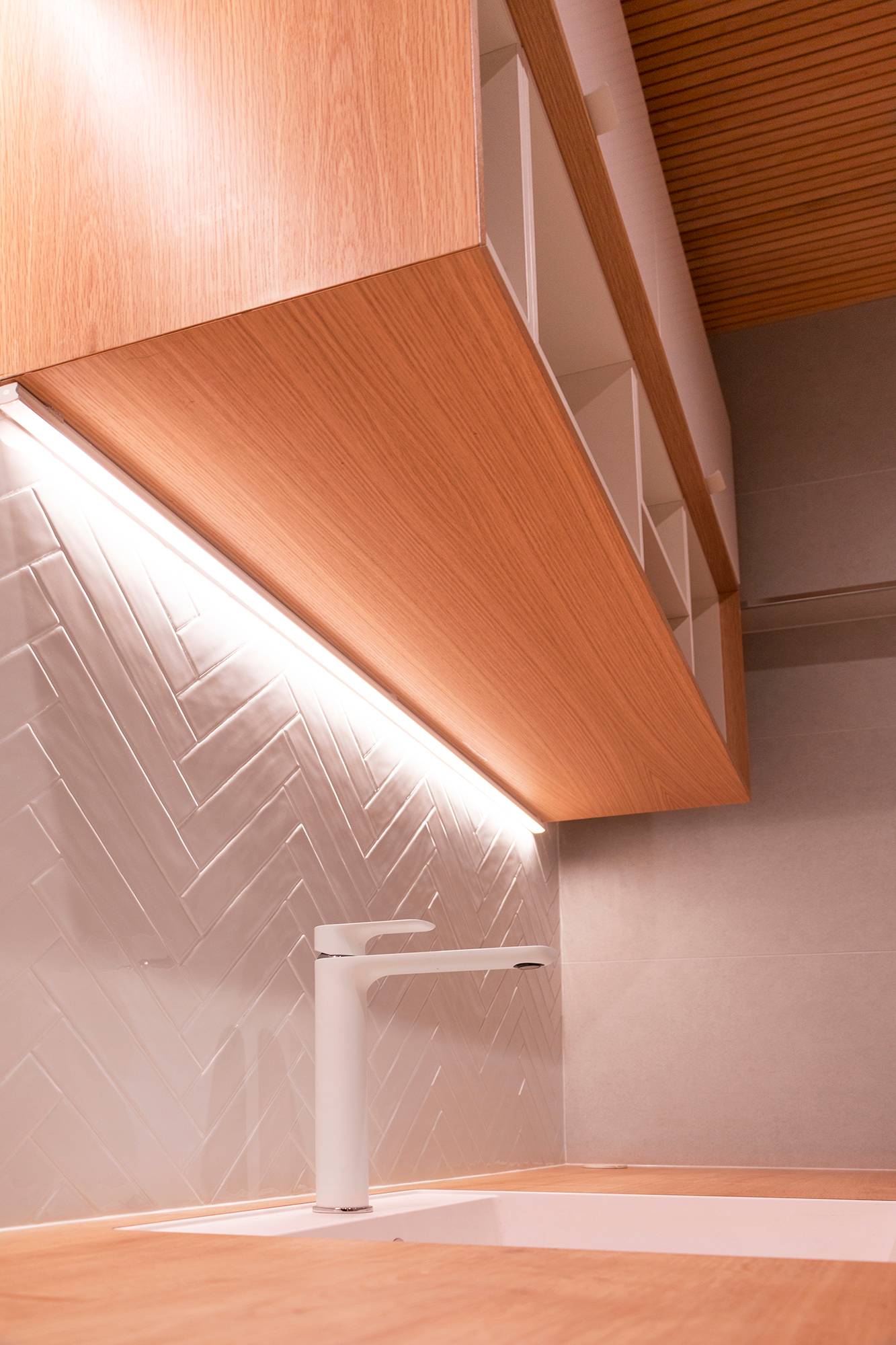 Dans le coin de l\'armoire, une bande LED met en valeur le carrelage et fournit un éclairage de travail. Ledstore.fi
