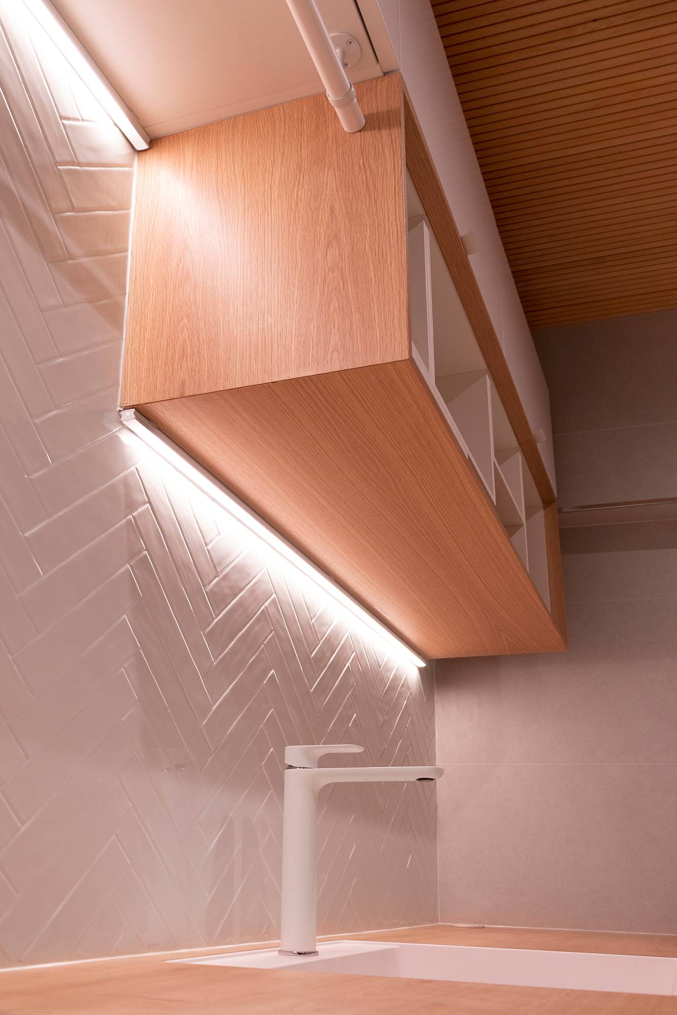Deux niveaux de bandes lumineuses dans l\'angle du meuble et du mur. Les bandes lumineuses mettent également en valeur le carrelage texturé. Ledstore.fi