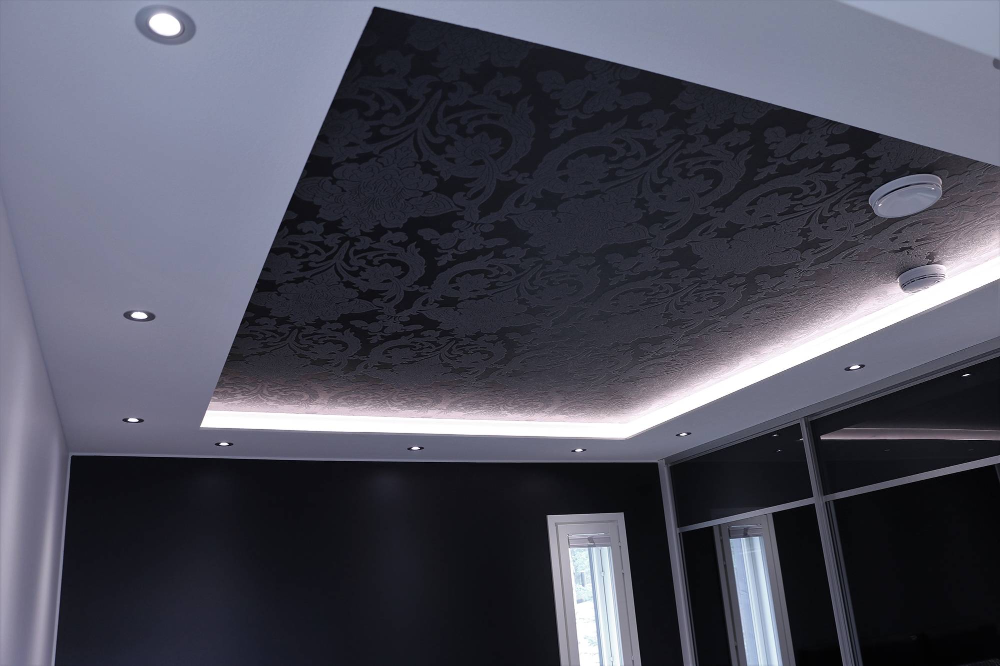 Un éclairage impressionnant dans la chambre à coucher. Des spots encastrés dans le plafond de l\'étage inférieur et une bande LED au-dessus du plafond de l\'étage inférieur, éclairant indirectement à travers le plafond. Ledstore.fi