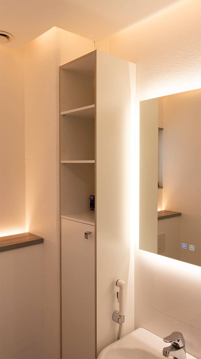 Lumière indirecte dans la salle de bains. Un miroir lumineux combiné à une lumière indirecte provenant du plafond et à une bande LED orientée vers le haut derrière la cabine de toilette. Ledstore.fi
