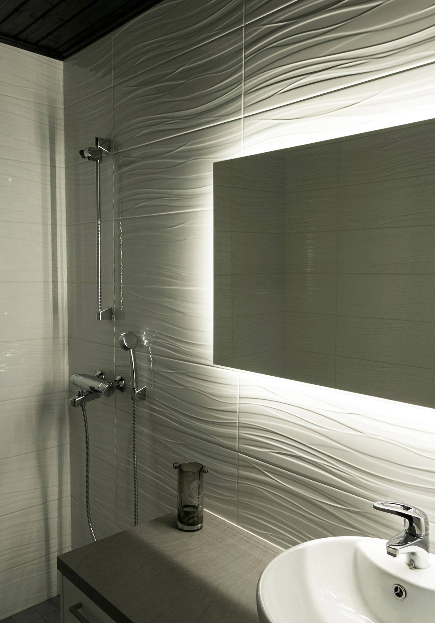 Une bande LED montée derrière un miroir fait ressortir le motif dans une salle de bains. Ledstore.fi
