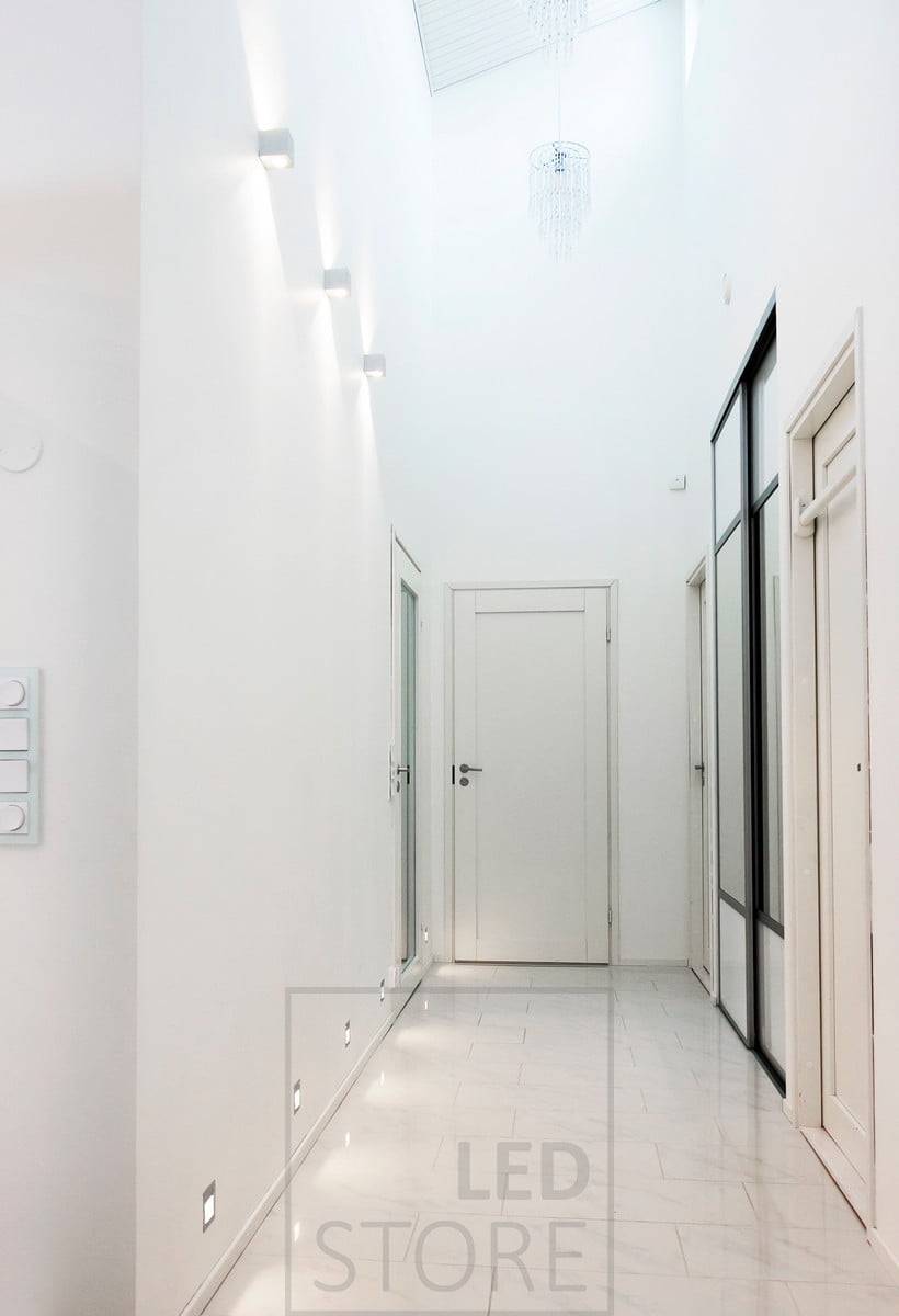 Les luminaires muraux encastrés IN-WALL créent une lumière indirecte dans le couloir au niveau du sol. En connectant les luminaires IN-WALL à un détecteur de présence, on obtient une solution fonctionnelle pour l'éclairage nocturne. Ces luminaires sont complétés par des luminaires muraux à leds bidirectionnels CUBIC pour accentuer la hauteur de l'espace. Ledstore.fi