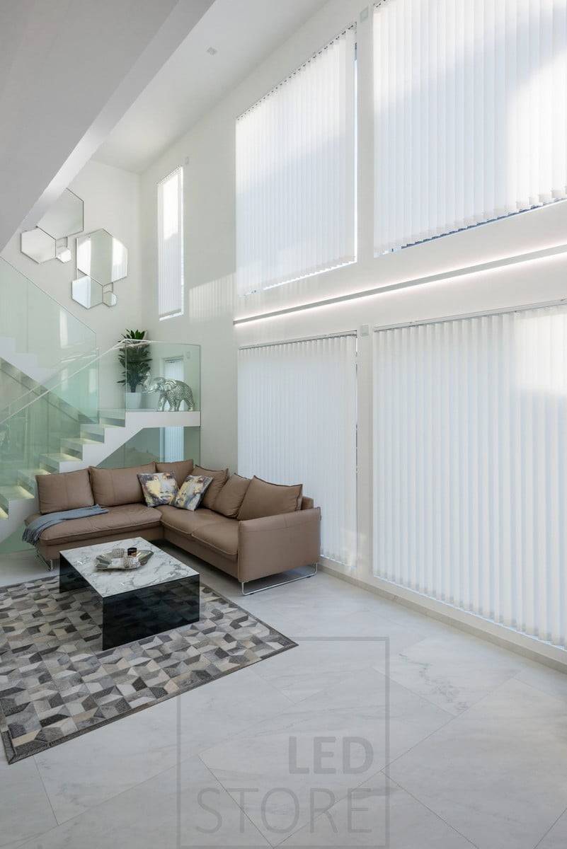 La hauteur du salon et des fenêtres est accentuée par des bandes de LED dans un profil bidirectionnel. Le profil et les bandes LED sont disponibles sur mesure. Un profil complet mesure 2,5 m de long. Le profilé bidirectionnel est également disponible en noir. Ledstore.fi