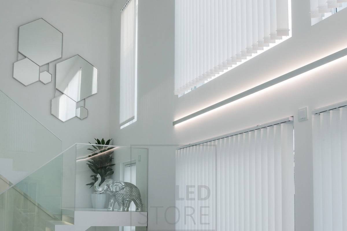 Bande LED dans un profilé mural bidirectionnel pour accentuer la hauteur et les fenêtres du salon. Le profil et les bandes LED peuvent être commandés sur mesure et prêts à être installés. Ledstore.fi