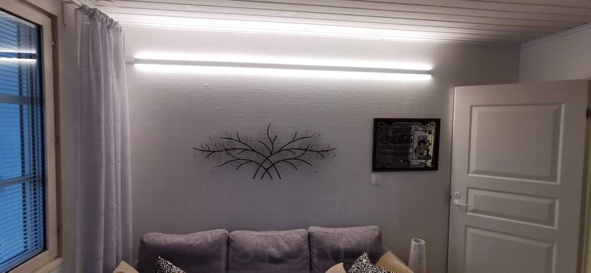 Derrière le canapé, sur le mur, un profilé LED bidirectionnel. Le profil a deux bandes de LED. Ledstore.fi