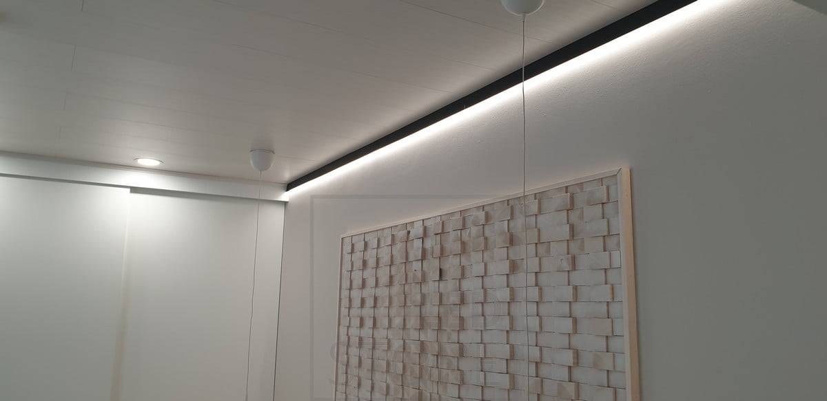 Dans la chambre, un profilé mural noir remplace la moulure du plafond. Une bande LED sur le profilé illumine le mur pour un éclairage d'ambiance indirect. Ledstore.fi