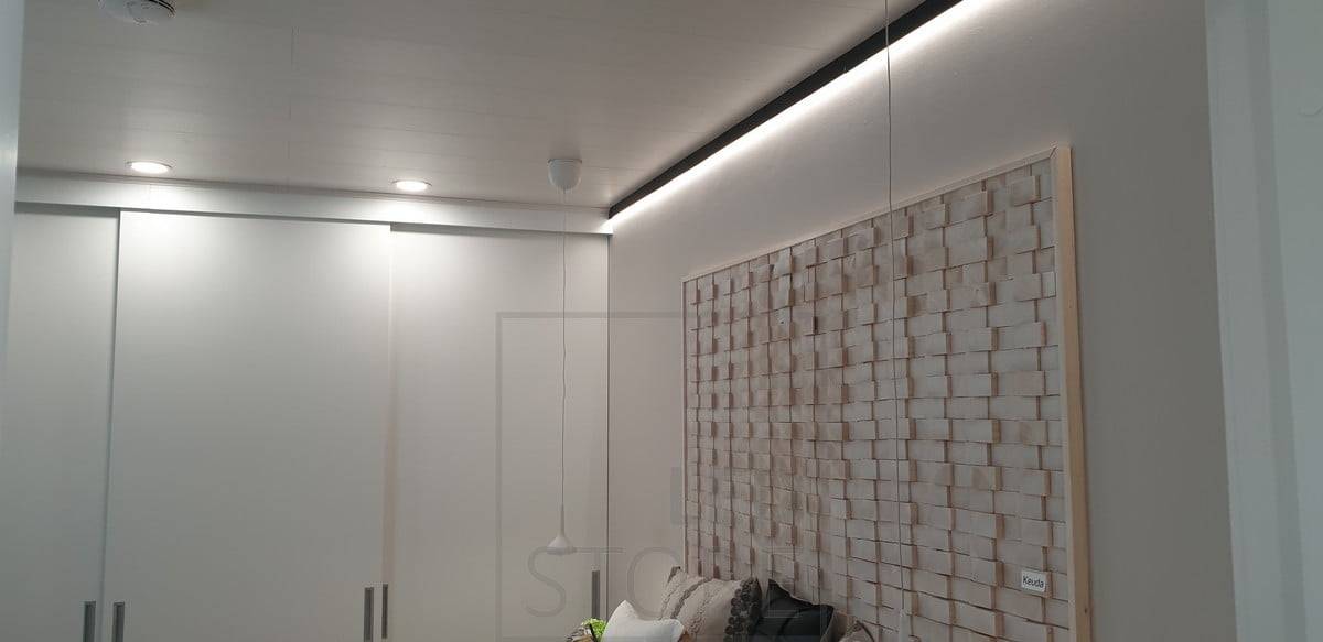 Un profilé mural noir au bord du toit remplaçant une latte de toit. Bande lumineuse à leds orientée vers le bas pour une lumière indirecte à travers le mur. Ledstore.fi