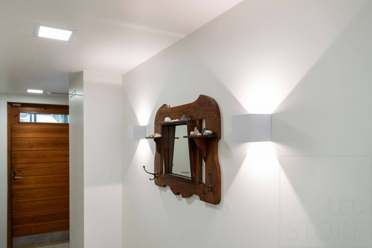Logo LED STORE : texte blanc sur fond vert avec "LED" STORE en haut. Le carré blanc est situé dans un magasin d'éclairage écologique.