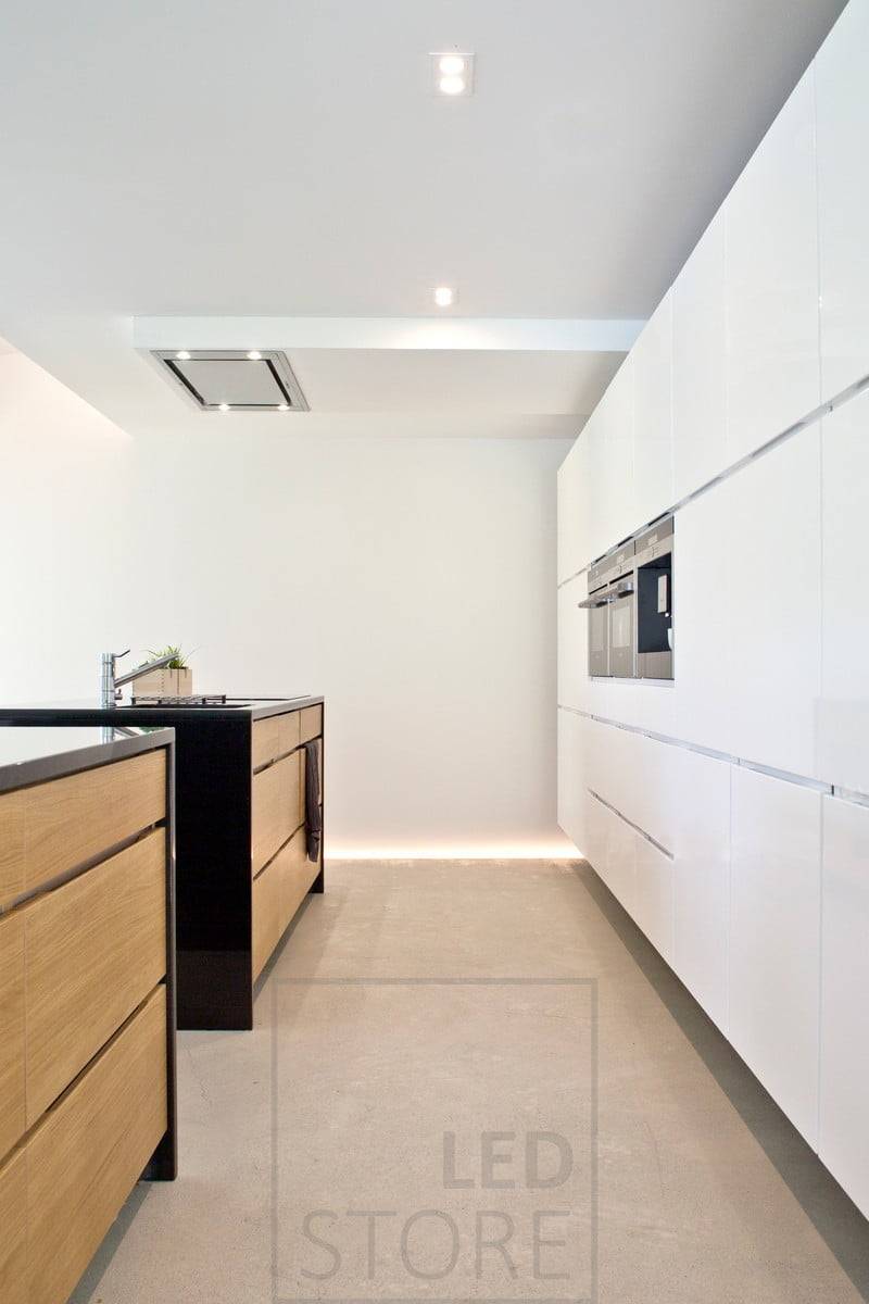 Dans la cuisine, éclairage d'ambiance indirect au sol et au plafond. Le sol est laissé avec une rainure dans la moulure remplie de pierres décoratives et une bande de LED installée dans le bord de la rainure. Ledstore.fi