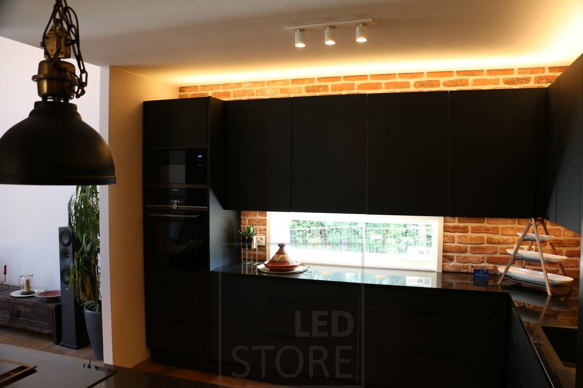 Au-dessus des armoires de cuisine, des bandes de LED éclairent la lumière indirecte, créant une lumière douce et atmosphérique. Un profilé LED fixé à la base des armoires éclaire le plan de travail. Ledstore.fi