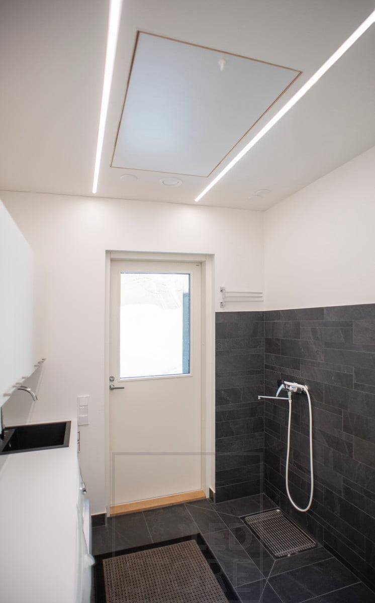 Des bandes de LED dans des profils encastrés dans le plafond créant un éclairage général dans l'espace. Ledstore.fi