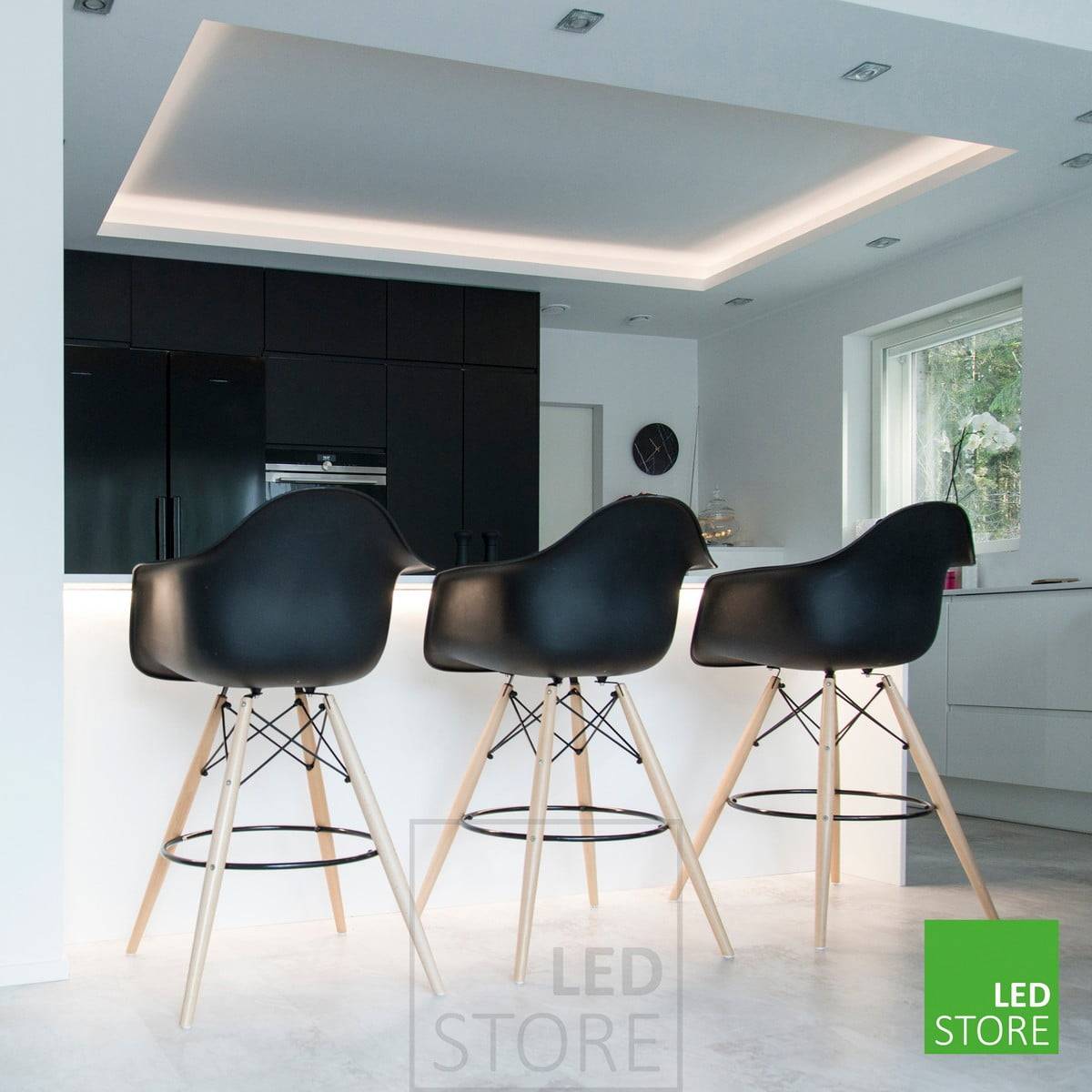 Dans la cuisine, un plafonnier avec des spots sur le rebord et une bande de LED orientée vers le bas sur le rebord de l'îlot. Ledstore.fi