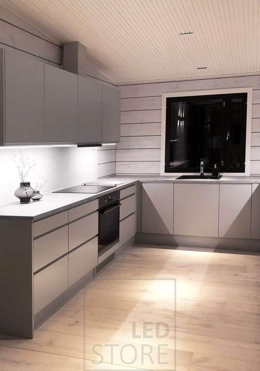 Eclairage de la cuisine - Bande LED en profilés d'aluminium au bas des meubles de cuisine supérieurs pour éclairer les plans de travail et spots LINJA au plafond. Ledstore.fi