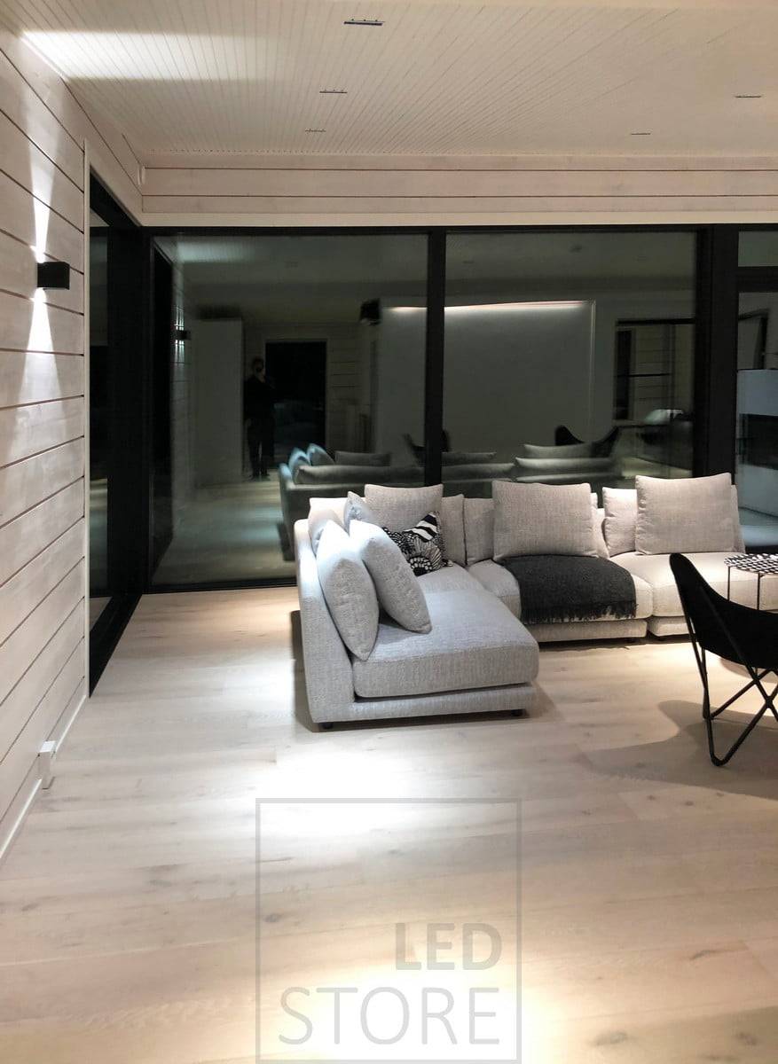Des spots LINJA comme éclairage de plafond dans le salon et une applique FUNK éclairant le mur dans deux directions pour un éclairage d'ambiance. Ledstore.fi