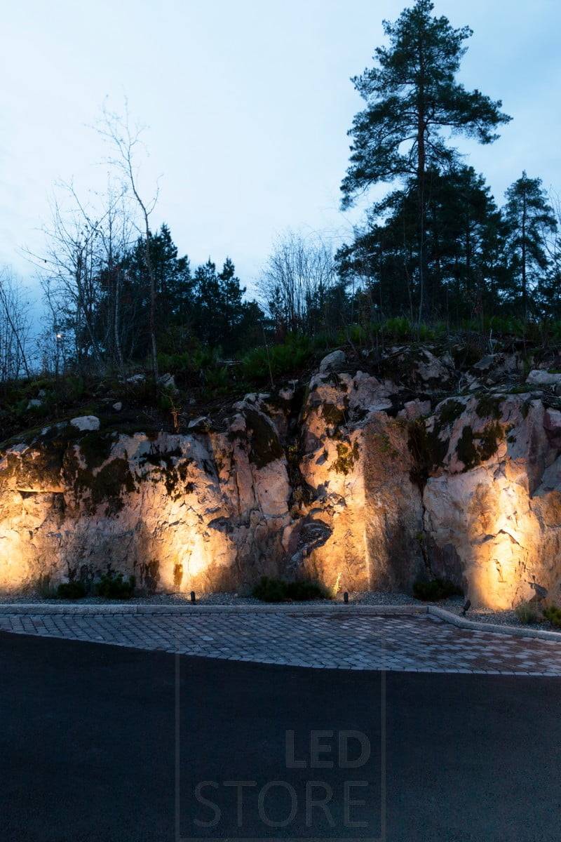 Luminaires de sol SPIKE éclairant un rocher d'une lumière atmosphérique et indirecte. Ledstore.fi