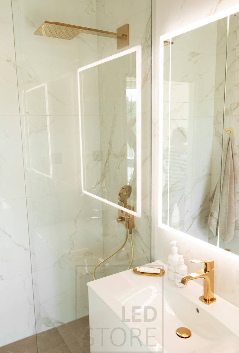 Le miroir lumineux HALO apporte une lumière atmosphérique et indirecte à travers le mur dans une salle de bain magnifique et luxueuse. Ledstore.fi