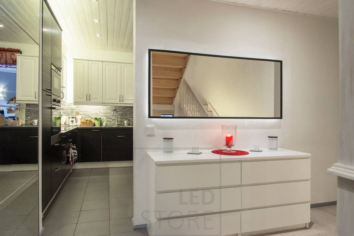 Bande LED montée sur le cadre derrière le miroir, qui éclaire le mur d'une lumière indirecte et met en valeur le miroir. Ledstore.fi