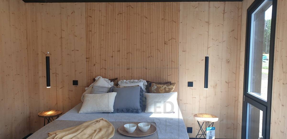 De chaque côté du lit, les suspensions PIPPU utilisées comme liseuses éclairent la pièce d'une lumière d'ambiance. Ledstore.fi