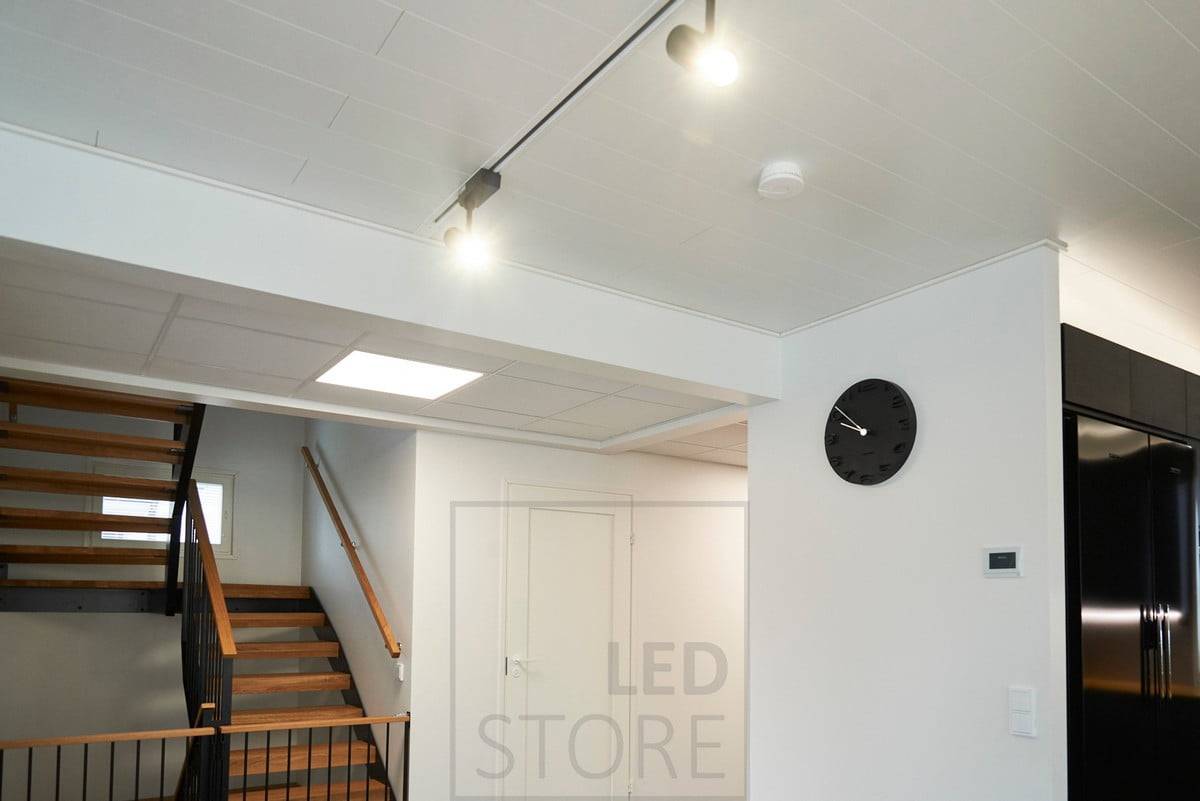 Un grand luminaire à panneau LED 600x600 dans le hall d'entrée créant un effet de puits de lumière. Ledstore.fi