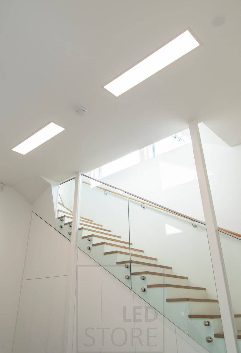 Panneau lumineux à leds UPPOAVA 300x1200 en rangée éclairant un couloir. Ledstore.fi