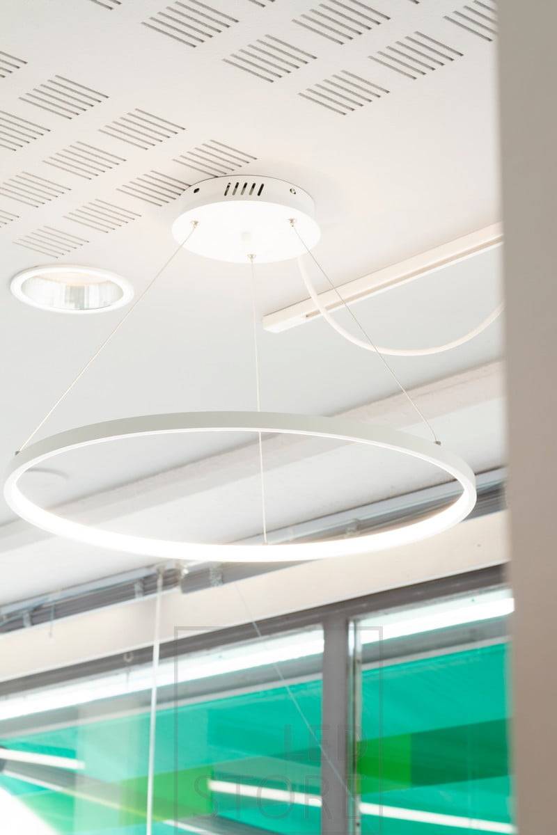 Luminaire suspendu RINKELI éclairant un bureau. La lumière passe à travers un diffuseur blanc, à partir de l'anneau intérieur du luminaire. Ledstore.fi
