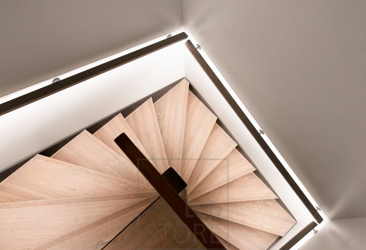 Ruban LED sur la rampe d'un escalier, orienté vers le bas. Illumine la lumière indirecte de l'escalier d'une manière douce et atmosphérique. Ledstore.fi