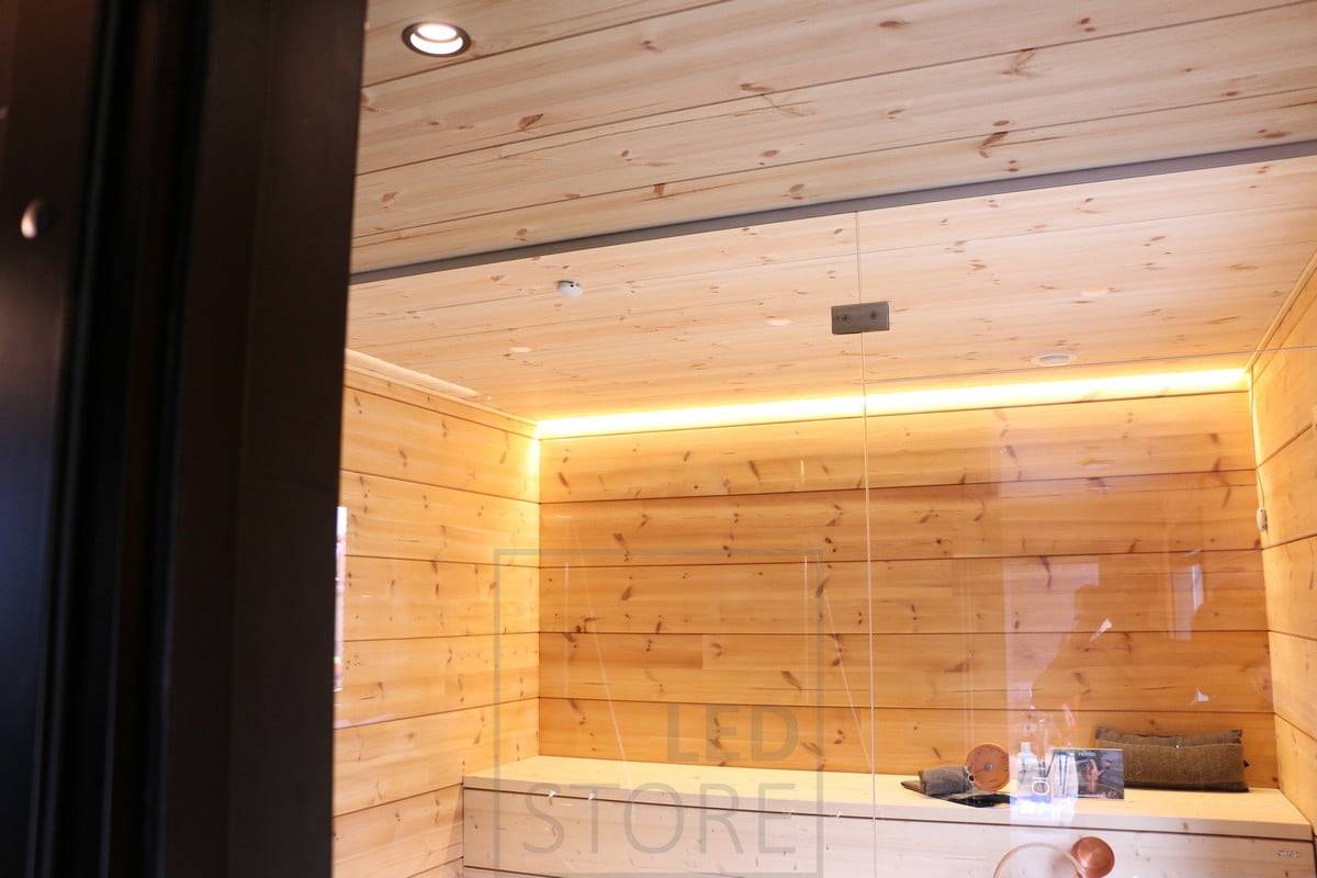 Bande LED sur le plafond du sauna créant une lumière indirecte atmosphérique dans la salle de sauna. Ledstore.fi