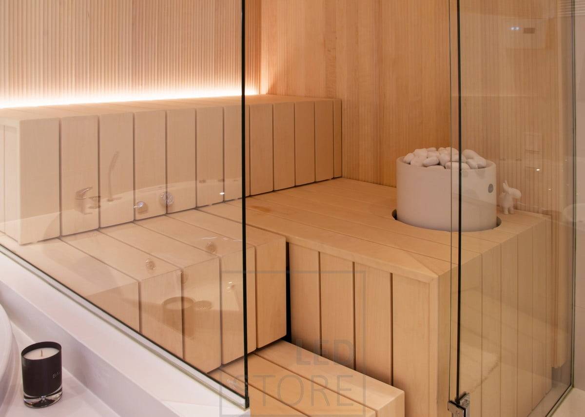 Eclairage de sauna avec bande LED dans la rainure derrière le banc, lumière dirigée vers le haut. Ledstore.fi