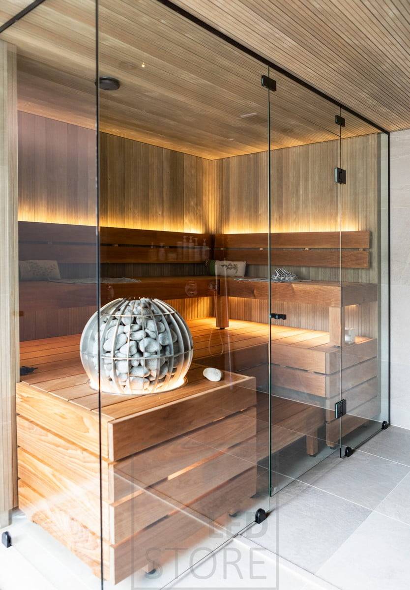 Éclairage d'ambiance pour le sauna créé par une lumière indirecte, avec la bande LED sur le dossier orientée vers le haut et sous le banc orientée vers le bas. Ledstore.fi