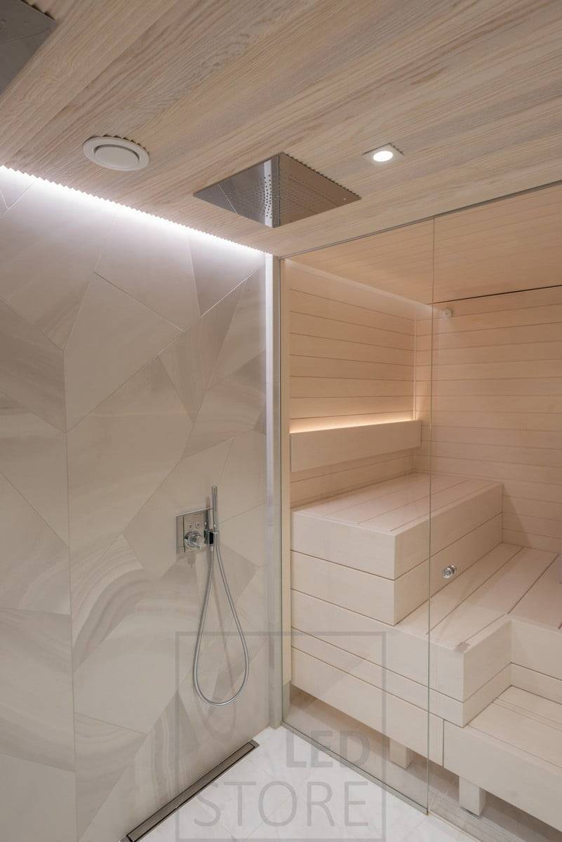 Lumière indirecte dans les toilettes et le sauna. Dans les toilettes, au plafond, dans une rainure entre le plafond et le mur ; dans le sauna, dans le dossier, orienté vers le haut. En outre, éclairage au plafond devant les douches. Ledstore.fi
