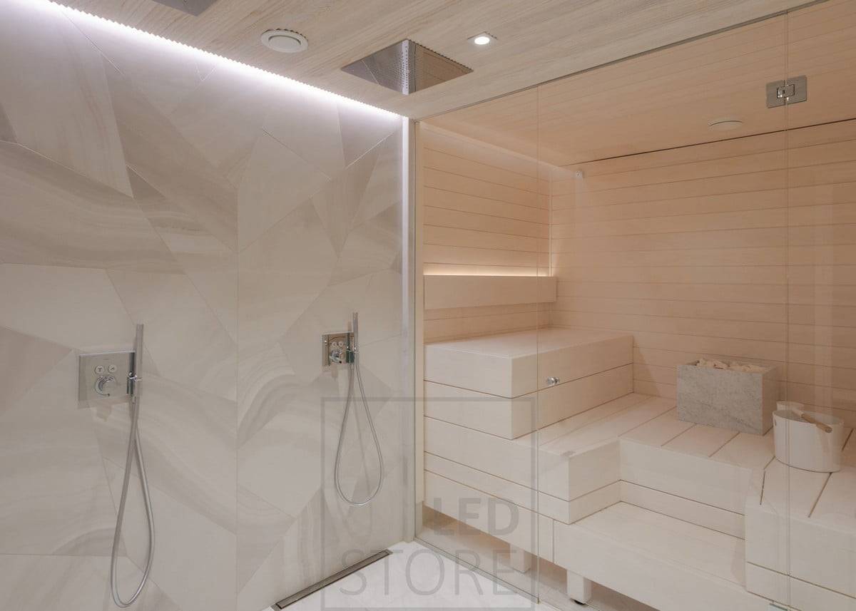 Lumière indirecte dans les toilettes et le sauna. Dans les toilettes, au plafond, dans une rainure entre le plafond et le mur ; dans le sauna, dans le dossier, orienté vers le haut. L'éclairage des toilettes illumine également le sauna grâce aux parois en verre. Ledstore.fi