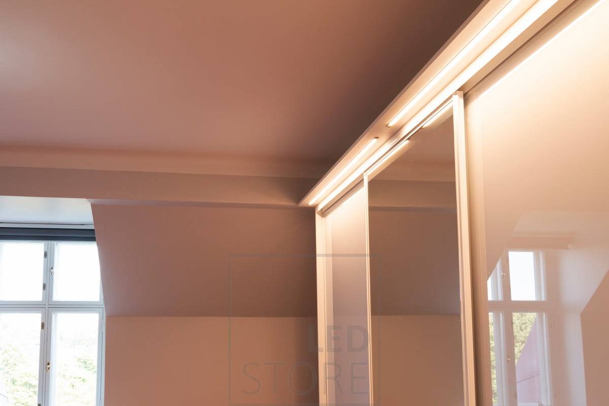 Ruban de diodes électroluminescentes dans un profil étroit et affleurant éclairant une armoire à vêtements. Ledstore.fi