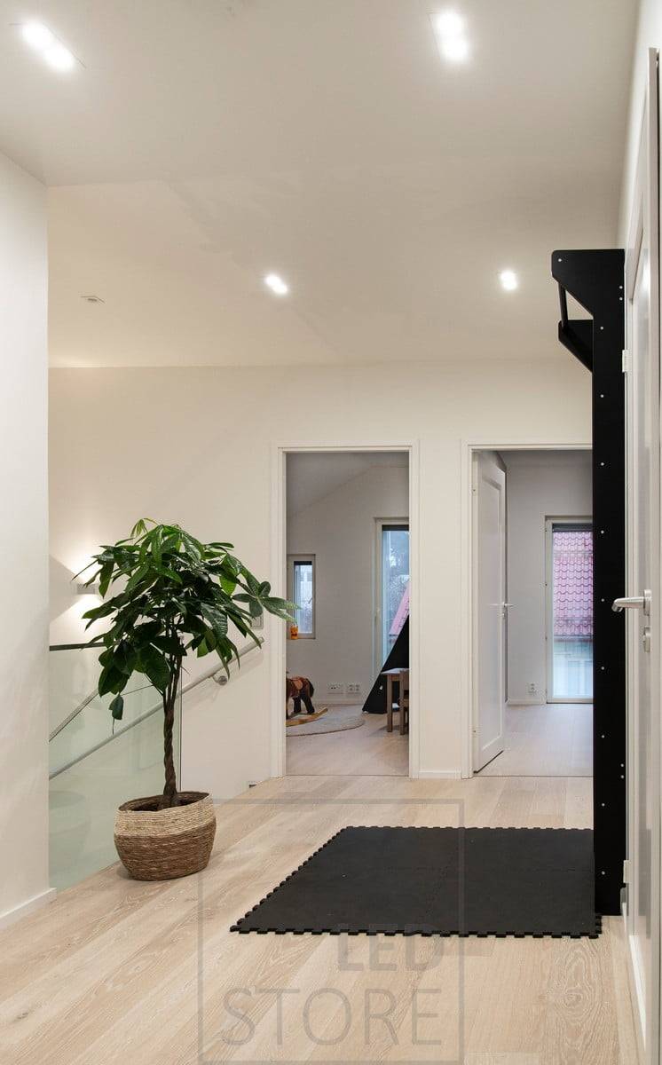Eclairage général avec des spots led TUPLAKANTTI au plafond et une applique murale bidirectionnelle au mur pour créer une lumière d'ambiance dans la cage d'escalier. Ledstore.fi
