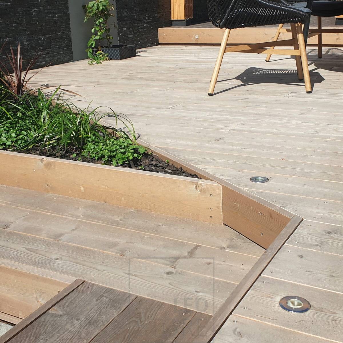 Lampe de terrasse éclairant vers le haut, encastrée dans la terrasse. Le corps est en acier inoxydable et résiste parfaitement aux intempéries. Ledstore.fi