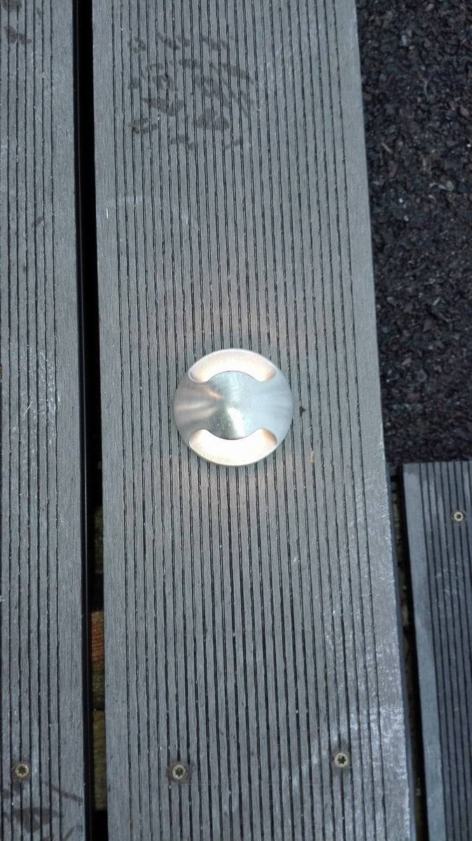 Un pot de terrasse encastré dans le sol. La lumière éclaire la terrasse dans deux directions. Ledstore.fi