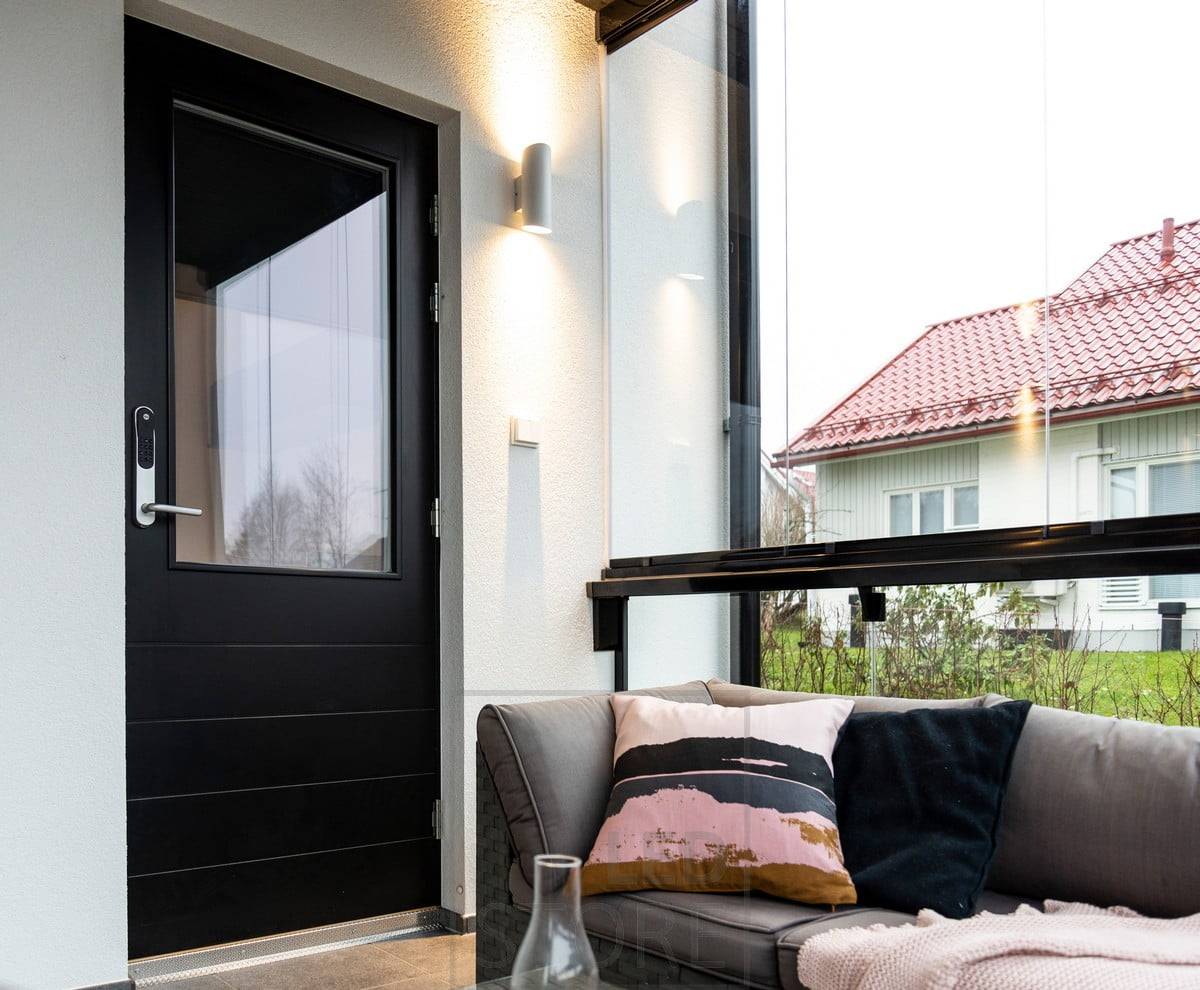 Applique murale Viisto blanche près de l\'entrée. Le luminaire éclaire le mur dans deux directions avec une lumière chaude et douce de 3000K. Ledstore.fi