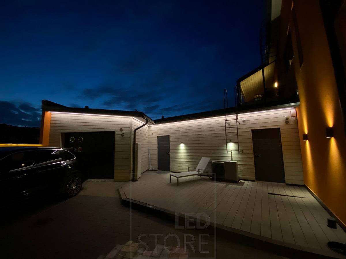 Bande LED sur l'avant-toit éclairant la façade d'un garage et d'un entrepôt avec une lumière indirecte. Ledstore.fi