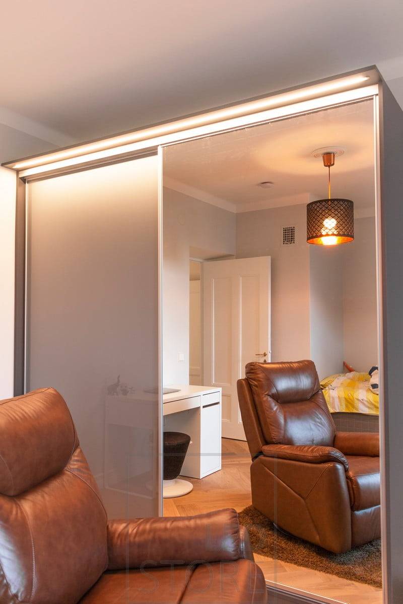 Une boîte construite sur le dessus d'une armoire avec un ruban de diodes électroluminescentes intégré dans le profil affleurant. Il fonctionne comme une excellente lampe et éclaire l'armoire et son contenu. Ledstore.fi