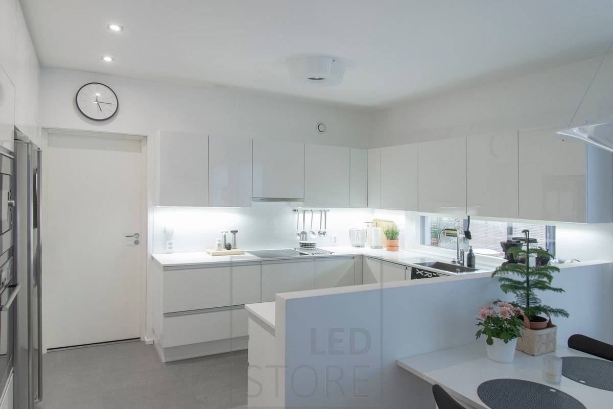 Une bande LED montée sur la base des armoires supérieures de la cuisine éclaire bien les plans de travail, les spots servant de lumières de couloir. Ledstore.fi